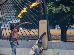 Seguidores del opositor Juan Guaidó lanzan bombas molotov en los disturbios de ayer. EFE/R. Peña
