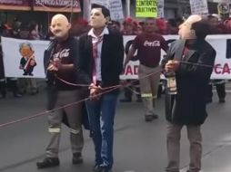 Sujetos con máscaras de los ex presidentes marchan atados a una cuerda. ESPECIAL