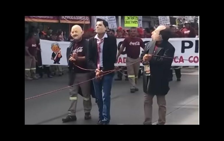 Sujetos con máscaras de los ex presidentes marchan atados a una cuerda. ESPECIAL