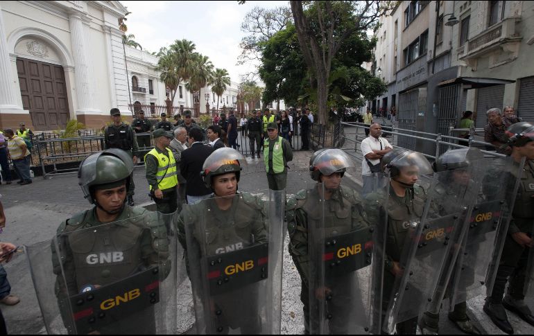 Miembros de la Guardia Nacional Bolivariana prestan guardia e impiden el paso de periodistas al edificio de la Asamblea Nacional, en Caracas. EFE/R. Peña