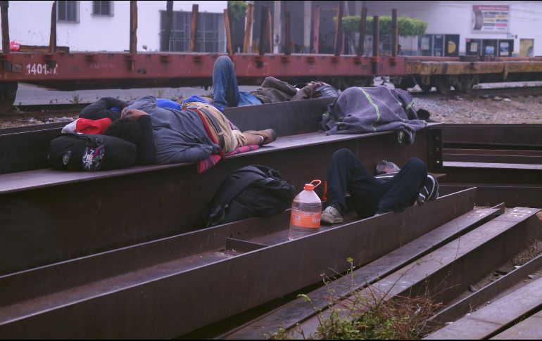 Migrantes centroamericanos descansan sobre las vías de tren en Arriaga. EFE/C. López