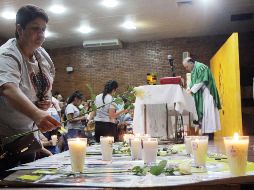 En el evento religioso las madres encendieron veladoras alrededor del altar y cerca de las fotos de sus hijos. EL INFORMADOR / E. Barrera