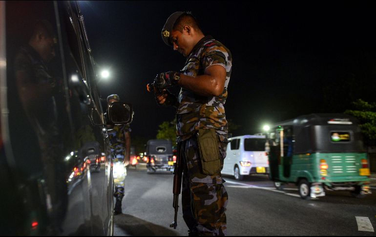 Un elemento de seguridad inspecciona un vehículo en un retén en Colombo. AFP/L. Wanniarachchi