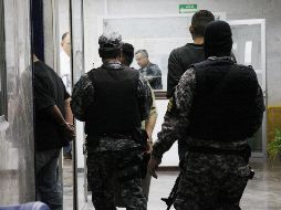 El joven con las manos camina hasta la unidad, mientras que otras personas se acercan y le piden a los oficiales las pertenencias de Martínez. EL INFORMADOR/ ARCHIVO