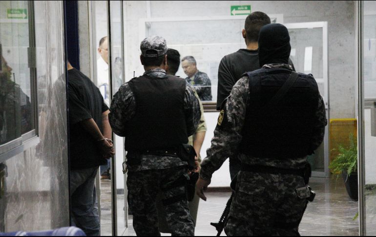 El joven con las manos camina hasta la unidad, mientras que otras personas se acercan y le piden a los oficiales las pertenencias de Martínez. EL INFORMADOR/ ARCHIVO