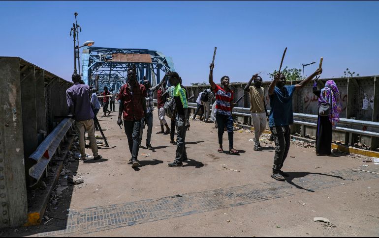 Manifestantes caminan hacia el lugar de la protesta, frente a la sede militar de Sudán. AP