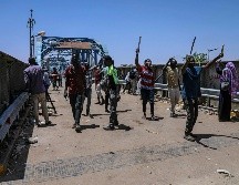 Manifestantes caminan hacia el lugar de la protesta, frente a la sede militar de Sudán. AP