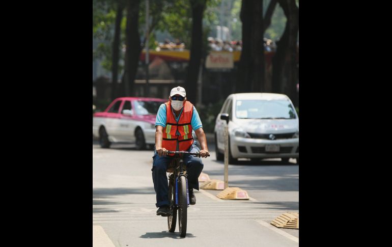 Aún con el elevado nivel de contaminación, ciclistas valientes salieron a rodar para llegar al trabajo. Eso sí, con cubrebocas. EFE