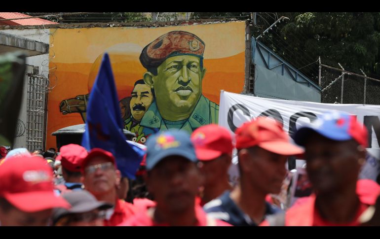 Un mural del fallecido expresidente de Venezuela, Hugo Chávez (c), se ve durante una marcha de simpatizantes del chavismo hoy en Caracas para celebrar el primer aniversario de las elecciones en las que el presidente Nicolás Maduro se proclamó ganador. EFE/R. Peña