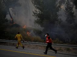 Bomberos trabajan a marchas forzadas para combatir las conflagraciones en medio de nubes de humo. AP/S. Schalit