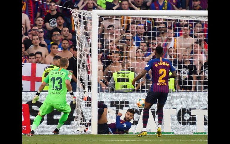 Piqué (en el suelo) evita un gol del Valencia barriéndose sobre la línea de gol. EFE/R. Caro