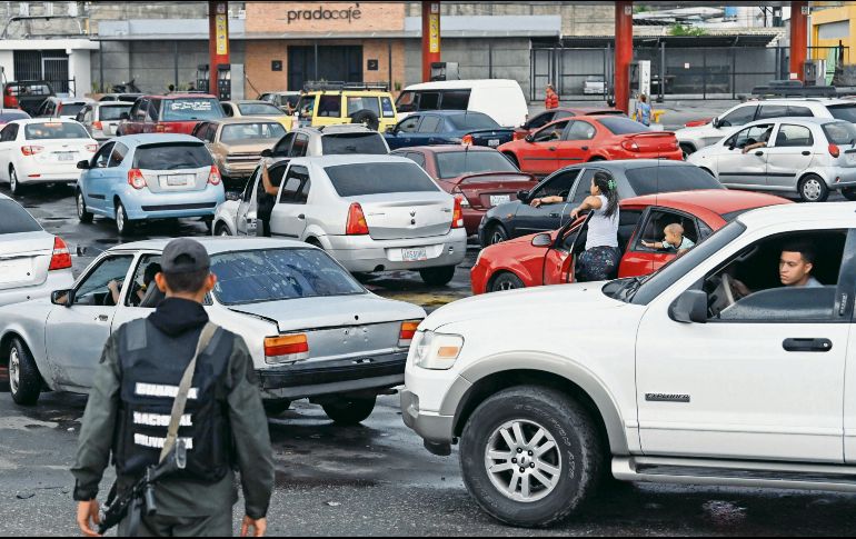 Conductores hacen fila para recargar en una estación de gasolina en Acarigua. AFP