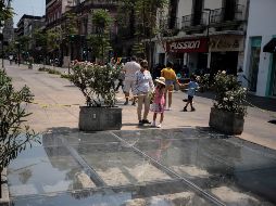 Curiosos se acercan a observar una de las siete “ventanas arqueológicas” en el primer cuadro tapatío. EL INFORMADOR/F. Atilano