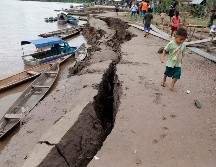 Un niño camina cerca de una grieta causada por el temblor este domingo, en Puerto Santa Gema, a las afueras de Yurimaguas, Perú. AFP/G. Pardo