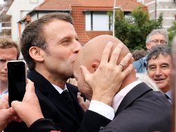 Emmanuel Macron besa a un simpatizante luego de emitir su voto en las elecciones europeas, ayer en Le Touquet, Francia. AP/ARCHIVO