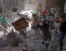 Voluntarios y militares rascatan a personas que quedaron atrapadas en un edificio derrumbado debido a los bombardeos. AFP/M. Haj Kadour