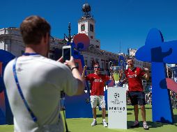 Aficionados del Liverpool posan junto a la “orejona”, que fue exhibida ayer en la Puerta del Sol. EFE/E. Naranjo