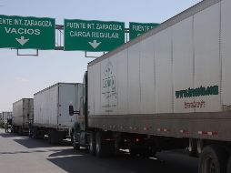 Camiones mexicanos que transportan principalmente productos automotrices esperan su turno para acceder a Estados Unidos, este viernes, desde Ciudad Juárez. EFE/D. Peinado