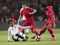 Zeki Celik le gana la pelota a Antoine Griezmann en partido del Grupo H, en el que los turcos sacaron los tres puntos para desbancar del primer sitio a los galos. EFE