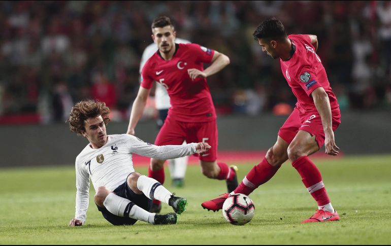 Zeki Celik le gana la pelota a Antoine Griezmann en partido del Grupo H, en el que los turcos sacaron los tres puntos para desbancar del primer sitio a los galos. EFE