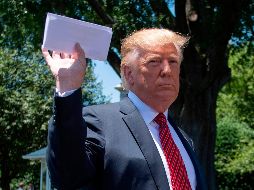 Donald Trump sostiene la hoja en la Casa Blance este martes, al afirmar que es el acuerdo con México. AFP/J. Watson