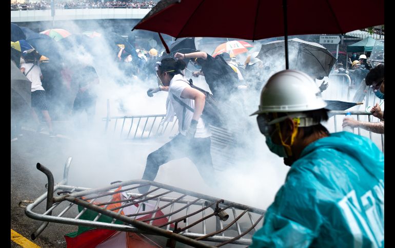 Manifestantes huyen de gases lacrimógenos durante la protesta de este miércoles en Hong Kong. AFP/P. Fong