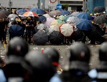 Decenas de protestantes con paraguas encaran a la policía, este miércoles en Hong Kong. EFE/V. Yuen