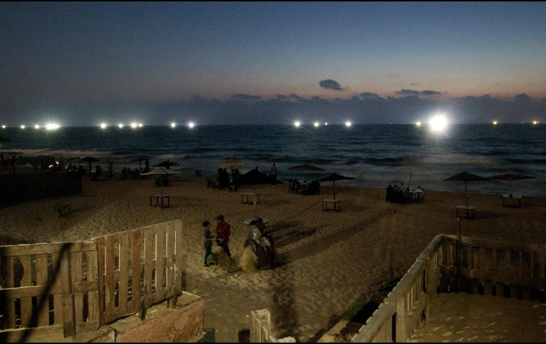 Palestinos descansan junto al mar Mediterráneo en Gaza. AP/H. Moussa