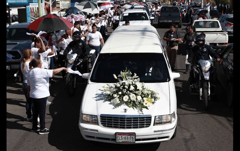 Personas observan el paso de la carroza con los restos de Norberto Ronquillo en Meoqui, Chihuahua. SUN/C. Torres