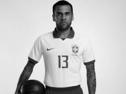 El defensa Dani Alves posa con la nueva equipación en una fotografía publicitaria en blanco y negro. TWITTER/@CBF