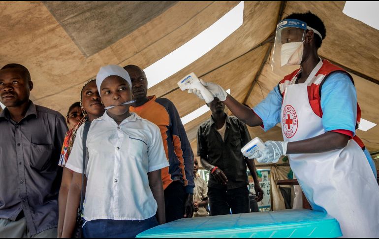 Trabajadores de la Cruz Roja de Uganda examinan este viernes en el puesto de control de Mpondwe, Uganda, para detectar síntomas de ébola en personas que cruzan la frontera desde la República Democrática del Congo. AP/R. Kabuubi