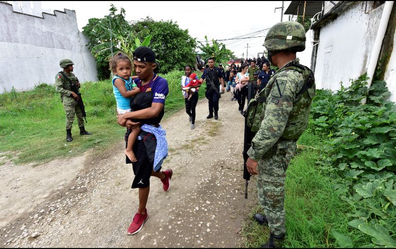 Militares y policías federales del estado de Tabasco custodian el paso de un grupo de migrantes en Tenosique. EFE/J. Ávalos