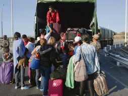 Venezolanos suben a un camión militar en Perú. AP