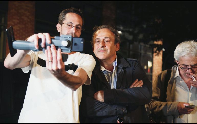 Después de pasar 15 horas detenido para un interrogatorio, Michel Platini se toma una selfie con un seguidor a las afueras de la Oficina Anticorrupción. EFE