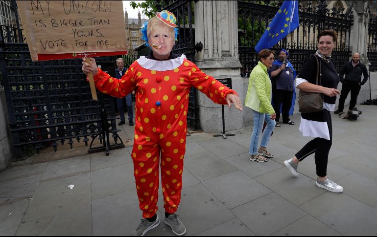 Un manifestante con una máscara de Boris Johnson se ve afuera de las casas del Parlamento en Londres. AP/K. Wigglesworth