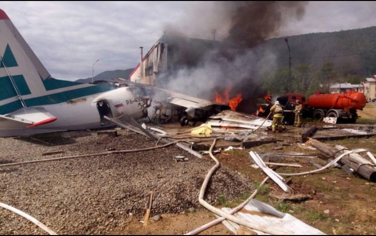 Bomberos tratan de apagar las llamas tras estrellarse un avión de pasajeros Antonov-24 contra una planta de tratamiento de aguas residuales, en la localidad de Nizhneangarsk. EFE/Ministerio de Emergencias ruso