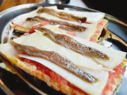 Tosta manchega y anchoa. una de las novedades del menú.