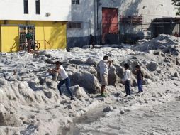 En las calles aledañas, otros vecinos armados con escobas y palas expulsan el hielo del interior de sus casas. Mientras vecinos y curiosos observan el hielo. EL INFORMADOR / J. Armendáriz
