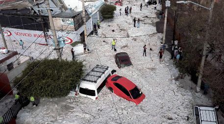 Vialidades de la zona industrial entre Guadalajara y Tlaquepaque amanecieron cubiertas de granizo el 30 de junio, tras una tormenta en la madrugada. Al menos 457 casas resultaron con daños. AFP