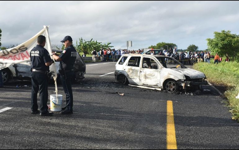 Policías investigan en el sitio del bloqueo en Tabasco. EFE