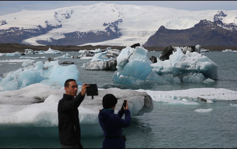 Turistas toman fotografías de Jokulsarlon, un gran lago glaciar en el sureste de Islandia, en el borde del Parque Nacional Vatnajokull. EFE/T. Zenkovich