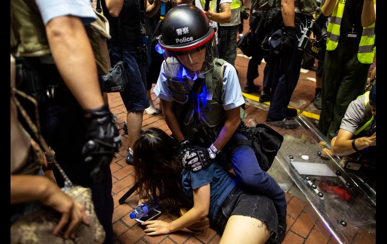 Un policía detiene un una manifestante tras la multitudinaria marcha en Hong Kong.