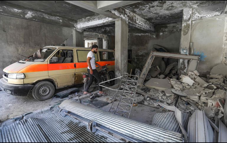 Un hombre pasa junto a una mini furgoneta dañada que se usó como ambulancia improvisada, en el garaje del hospital dañado después del ataque aéreo. AFP/O. Haj Kadour