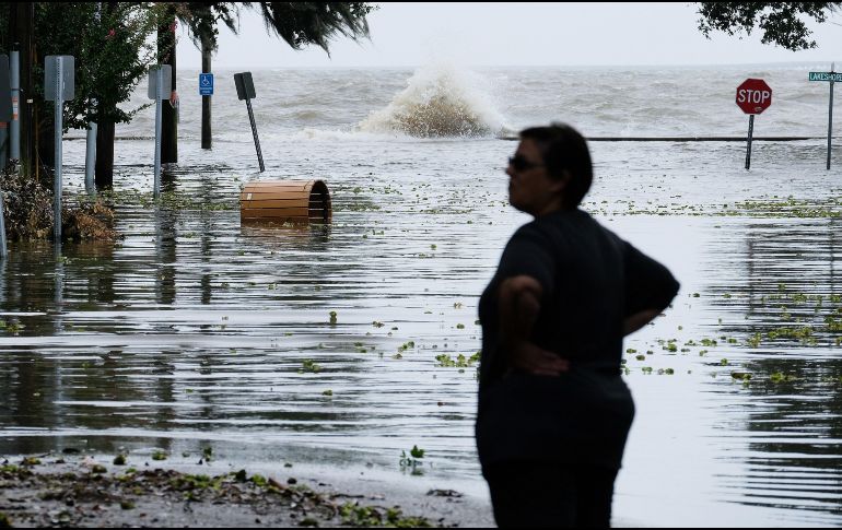 Una mujer observa una carretera inundada poco antes de la llegada de 