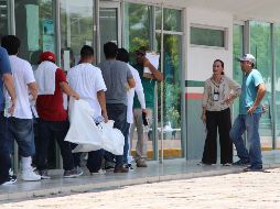 Migrantes deportados colocan sus pertenencias en bolsas blancas este sábado al cruzar por la garita Puente Nuevo, en el paso fronterizo de Matamoros. EFE/A. Pineda