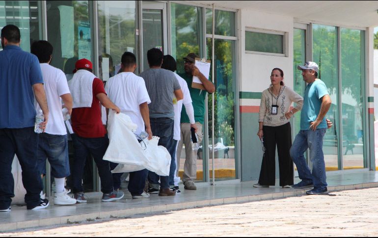 Migrantes deportados colocan sus pertenencias en bolsas blancas este sábado al cruzar por la garita Puente Nuevo, en el paso fronterizo de Matamoros. EFE/A. Pineda
