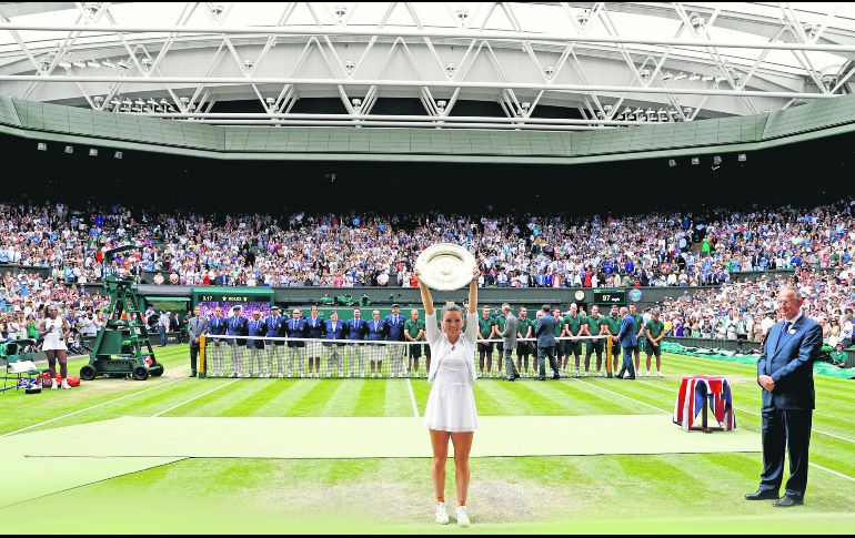 Simona Halep alza su trofeo de campeona tras vencer en la Final a Serena Williams, quien en el papel lucía como favorita. EFE