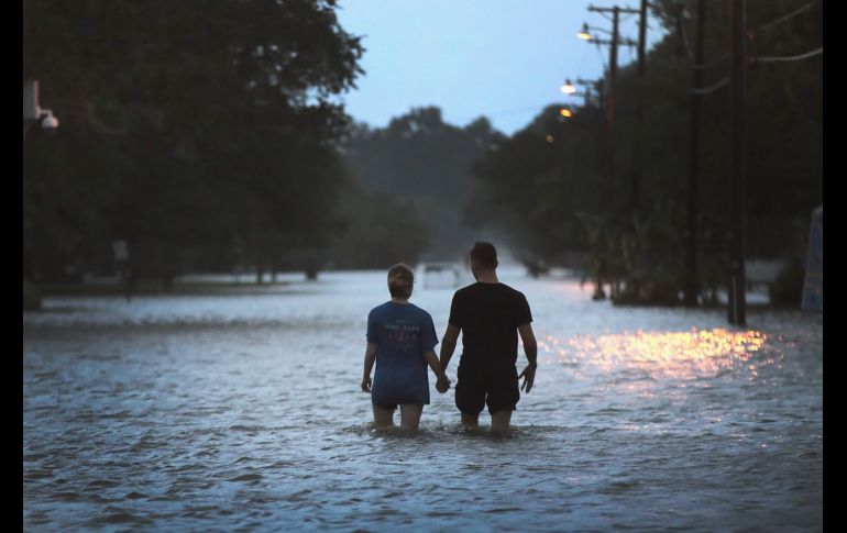 Una pareja en una calle inundada el sábado tras el desbordamiento del lago Pontchartrain en Mandeville, Luisiana.