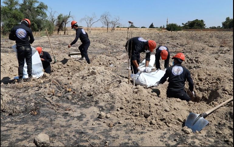 Trabajadores desentierran restos humanos de una fosa común el domingo en Raqqa. AP