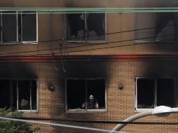 Bombero realiza labores de limpieza tras apagar el siniestro. EFE